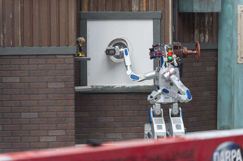 The HUmanoid roBOt, HUBO, from the Korea Advanced Institute of Science and Technology (KAIST), cuts a hole in drywall during the Defense Advanced Research Projects Agency (DARPA) Robotics Challenge (DRC) June 5 in Pomona, California. The DRC is a