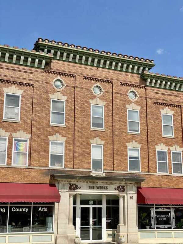 Built around the turn of the 20th Century, this Renaissance Revival-style building features an orange brick facade, divided into five bays by pilasters with brick corbeling above the third floor windows, stone window headers, a heavily bracketed