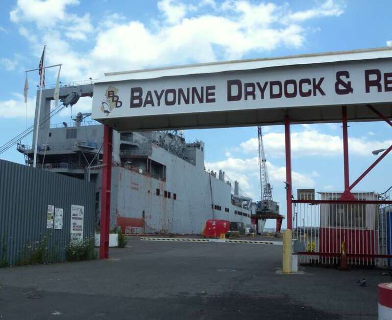 Looking east into ship in repair yard drydock on a clouding up midday.
