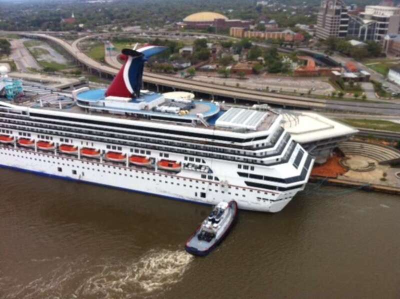 A tug vessel pushes the Carnival Triumph to moor at the Signal International shipyard on the Mobile River, April 3, 2013. The cruise ship broke loose from a BAE Systems dry dock after strong winds from a storm. (U.S. Coast Guard photo)
U.S. Coast