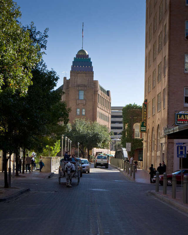 Street scene in downtown San Antonio. Horse drawn carriages are available for rent near the Alamo. The drivers will carry their passengers around the downtown area, pointing out various landmarks and points of interest.