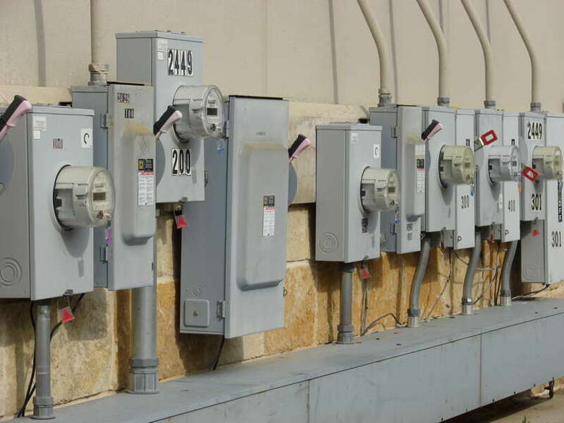 Electrical power junction boxes and meters outside a strip mall.