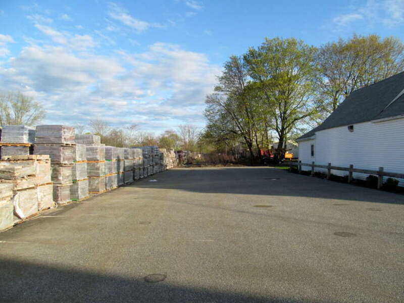 Site of the 1959-1981 Woburn station in April 2016. The station shelter was located about at the near stacks of lumber on the left.