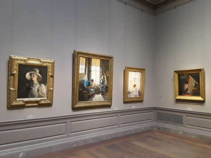 Gallery display of American paintings formerly in the collection of the Corcoran Gallery of Art, now at the National Gallery of Art in Washington, D.C. Visible paintings are (from left):
Frank Weston Benson, My Daughter (1912)
Daniel Garber, South