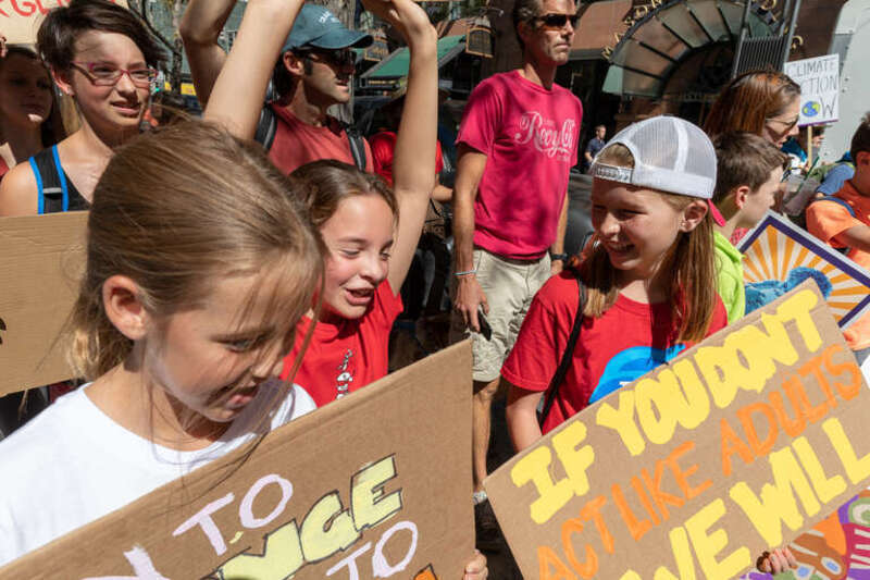Three girls laugh while marching in the Global Climate Protest on the 16th Street Mall in Denver. Photo: Andy Bosselman, Streetsblog Denver