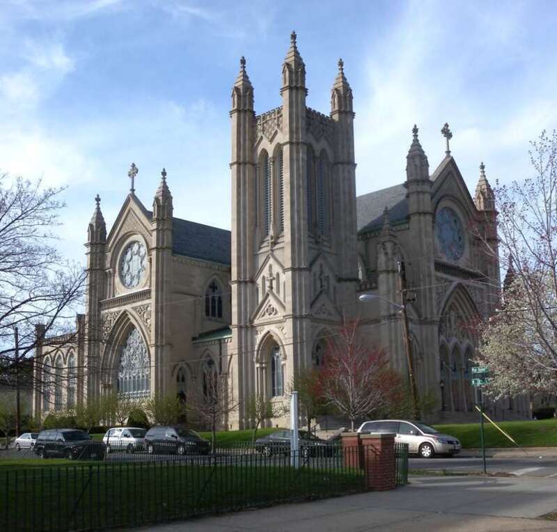 Looking north across Avenue C and 23d Street at Saint Henry Catholic Church on a sunny afternoon.