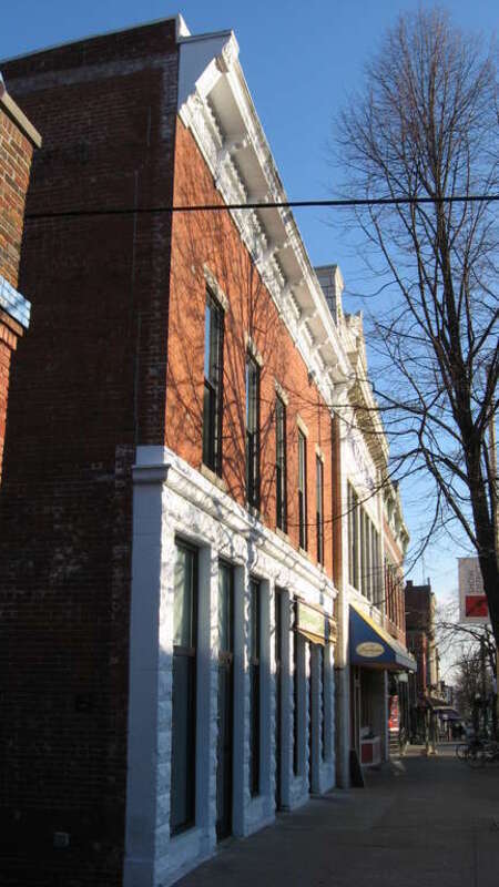 Building facades on the eastern side of the 200 block of N. Walnut Street in downtown Bloomington, Indiana, United States.  Three buildings are visible in the picture: the Faris Market (208 N. Walnut) closest, the Princess Theatre (206 N. Walnut) in
