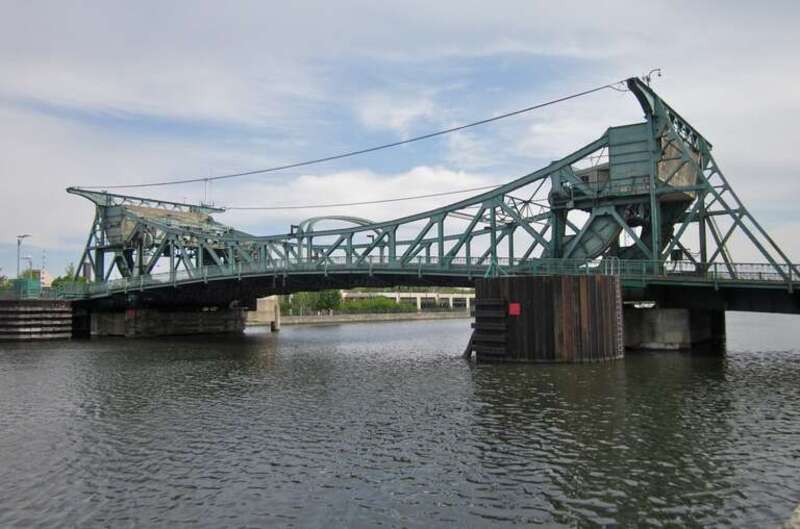 The north side of the Jefferson Street Bridge, in Joliet, Illinois, viewed from the west riverbank. It carries eastbound US Route 30.  It is one of four Scherzer Rolling Lift bascule bridges in Joliet, all of which span the Des Plaines River.