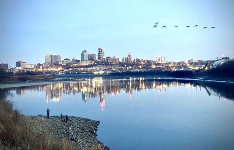 The Kaw Point overlook at Kaw Point Park is in Kansas City, Kansas. It views the land formation point, the confluence of the Kansas River to the right and the Missouri River to the left, and downtown Kansas City, Missouri on the horizon. A family