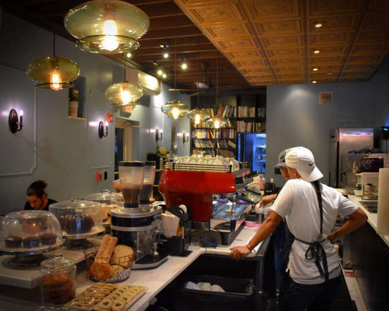 Management discusses preparation of a coffee beverage, cortadito con oscurito non mediano, not yet on the menu.