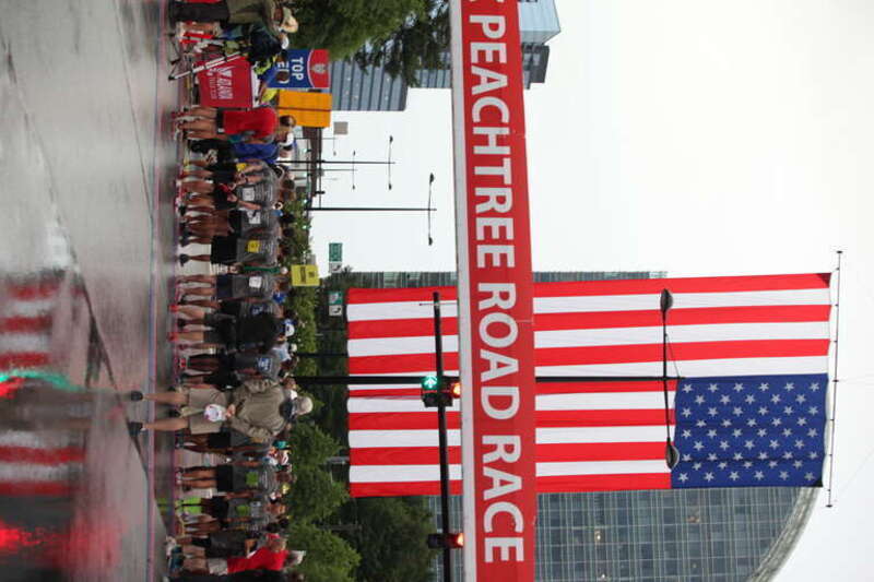 ATLANTA, July 4, 2015 - Members of every branch of the United States Military line up at the starting line of the Peachtree Road Race for the National Anthem.
Men and women from every military branch run to show their support of military children all
