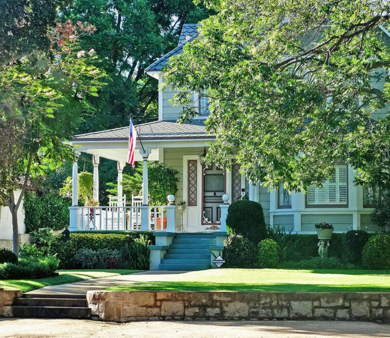 (1 in a multiple picture album)
These folks proudly fly our flag on the front porch of their beautifully maintained home in Redlands, CA. Note the cut-stone wall in front.  The gutters in the older section of town are made from cut-stone and they are