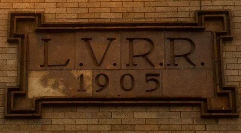 As seen in January 2020, the inscription above the entrance to the Dinosaur Barbecue restaurant in downtown Rochester, New York indicates its former function as the local Lehigh Valley Railroad depot.