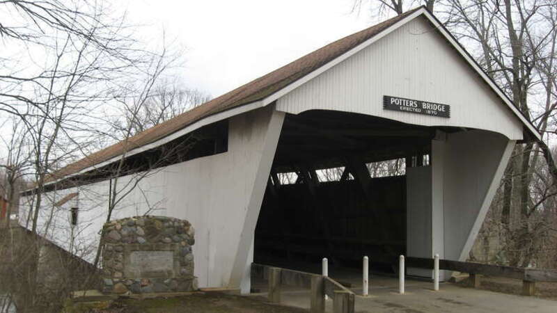 Southern portal and western (downstream) side of Potter's Covered Bridge, which spans the White River north of Noblesville in Noblesville Township, Hamilton County, Indiana, United States.  Built in 1871, it is listed on the National Register of