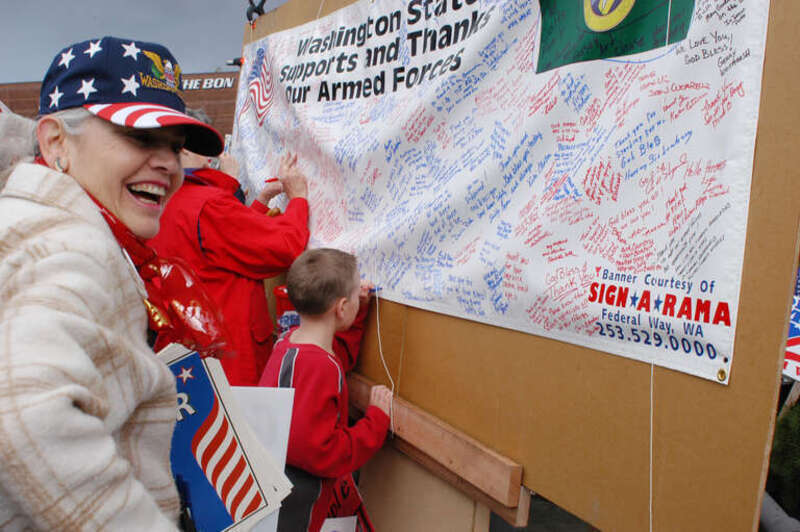Bellevue, Wash. (Mar. 22, 2003) -- Local residents sign one of many banners being sent to the troops over seas during a troop support rally in Bellevue hosted by Operation Support Our Troops. The mission of Operation Support Our Troops is to provide