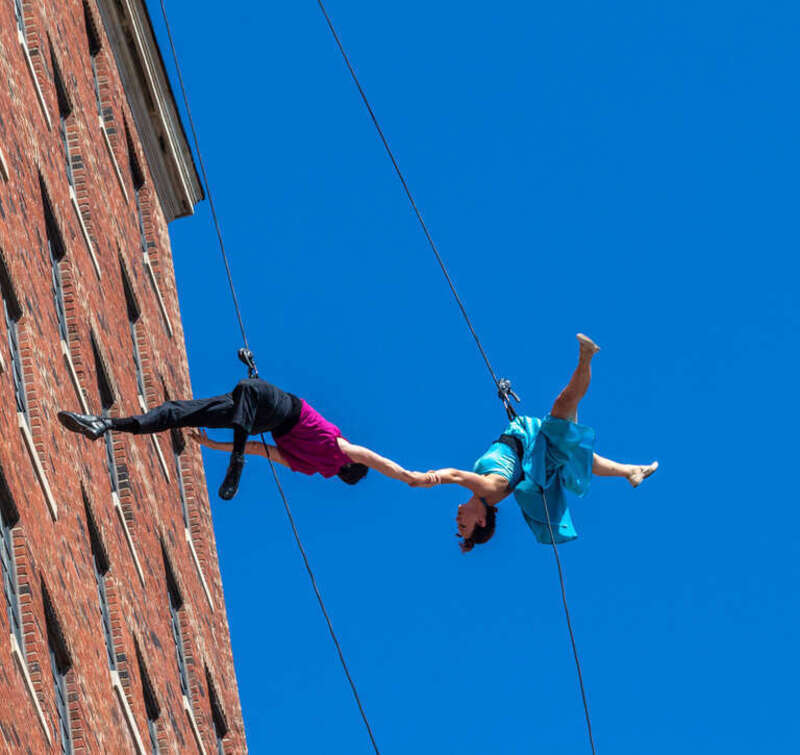 The dance troop, Bandaloop, perforned a 'vertical dance' on the face of one of the walls of the Westin Harborview Hotel in Portland, Maine with two short performances at mid-day.  Lots of harsh light.  
A pioneer in vertical dance performance,