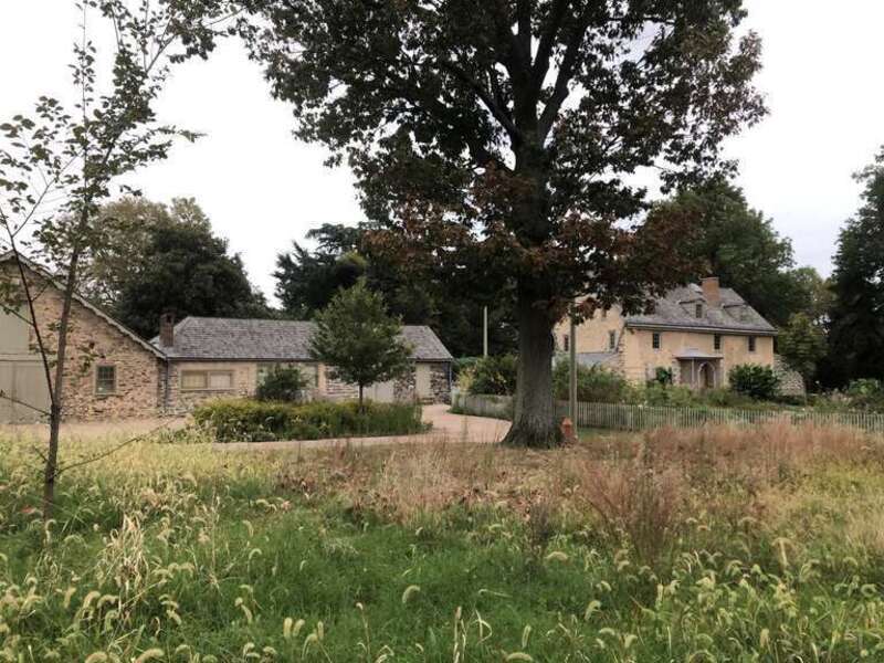 View through front meadow garden of John Bartram's estate and historical stone buildings at Bartram's Garden in Philadelphia, PA