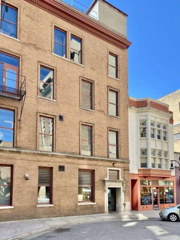 Built in 1900 and expanded in 1908, this Beaux Arts-style flatiron building was designed by Gordon and Paunack to house the Commercial National Bank, and is known as the Wisconsin Building.  The building is flatiron-shaped with a curved corner, and