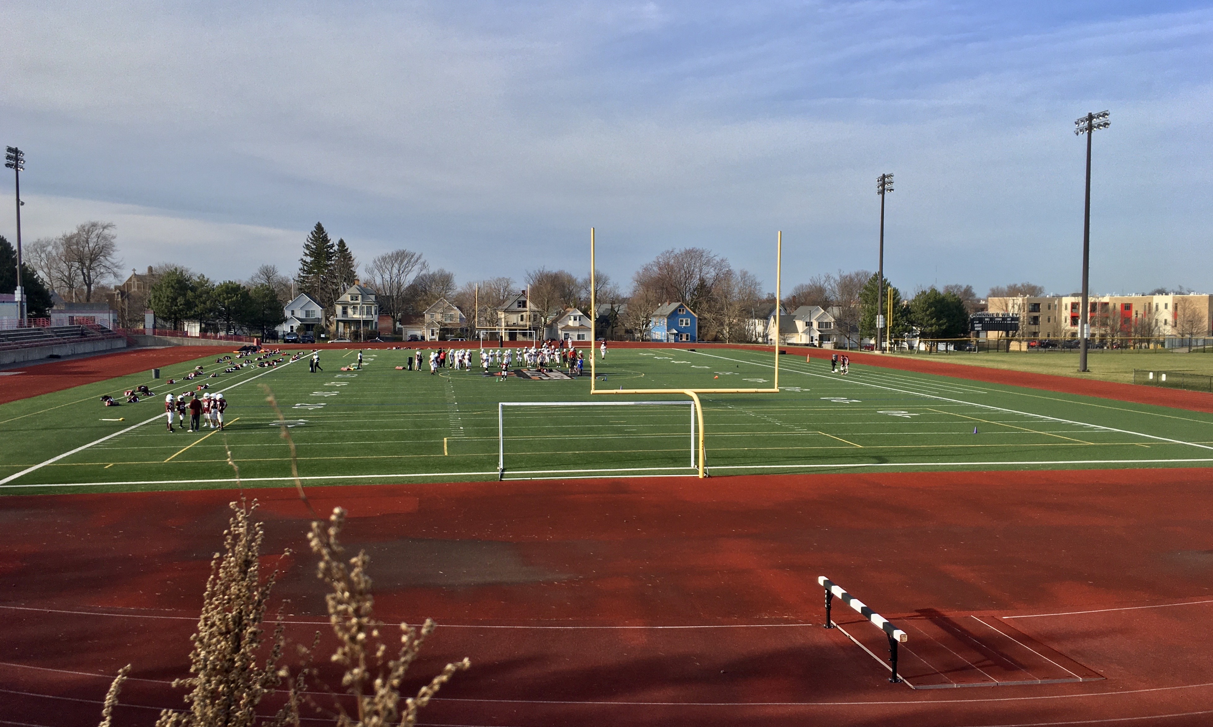 A local high school football team practices on the field at Johnnie B. Wiley Amateur Athletic Pavilion in Buffalo, New York, as seen on an unseasonably warm March 2021 afternoon.