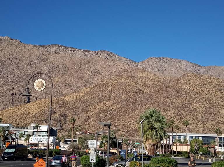 A round sign with the insignia of the Agua Caliente Band of Cahuilla Indians, suspended from a streetlamp post in downtown Palm Springs, California.