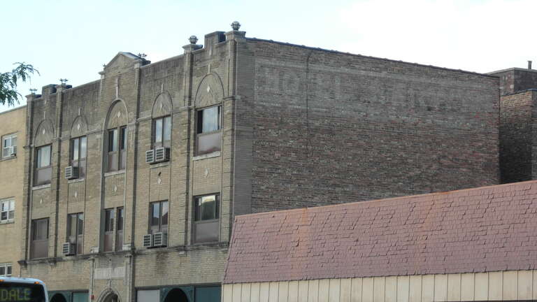 The Berwyn Hotel in July 2017 from the southwest. Hotel Berwyn ghost sign is visible.