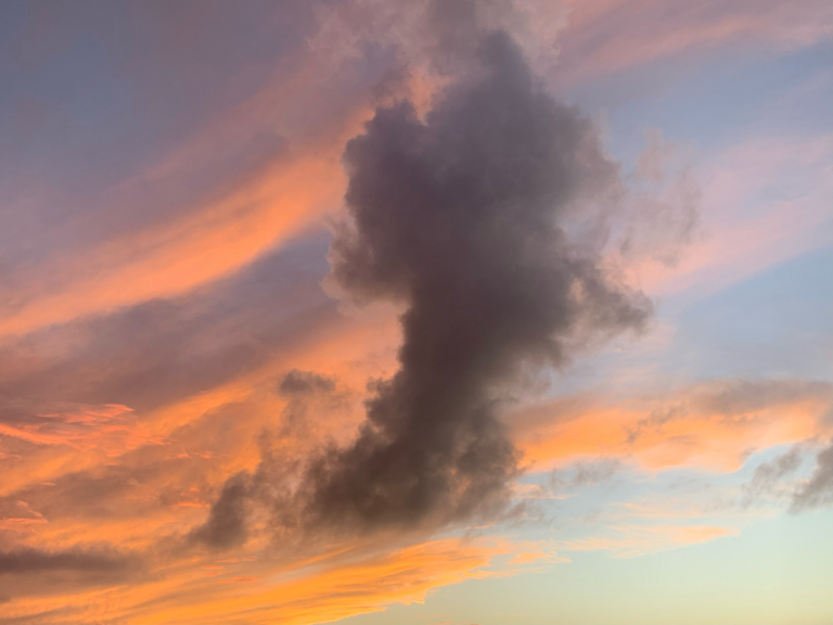 This file shows a stunning picture of the sky as seen in Miami, Florida during the winter time. The fascinating contrast between a reddish cloudiness and clear cyan sky is highlighted by a column of dark grey rainclouds.