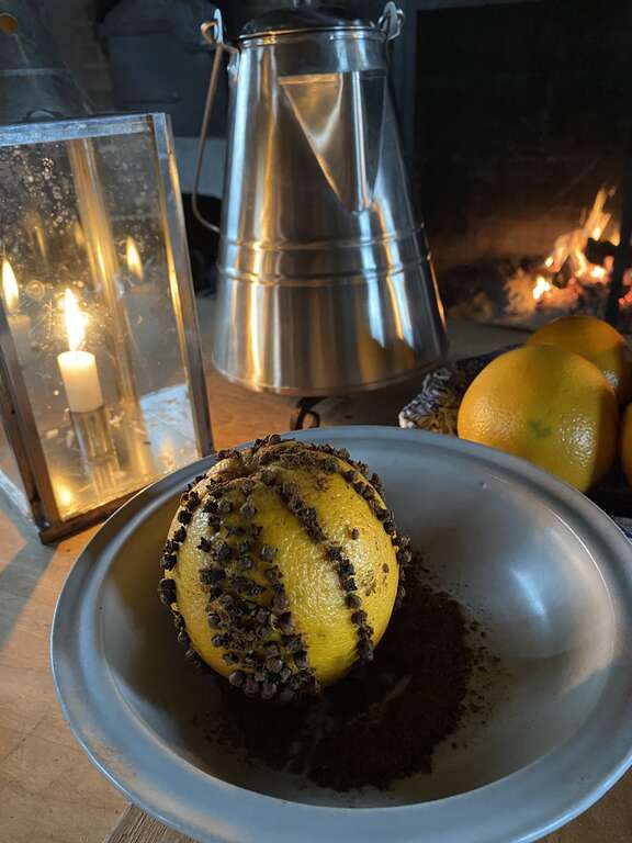 A pomander in a bowl of spices.
Optional: Combine cinnamon, nutmeg, and allspice, and roll the clove-studded orange in this spice mixture.
