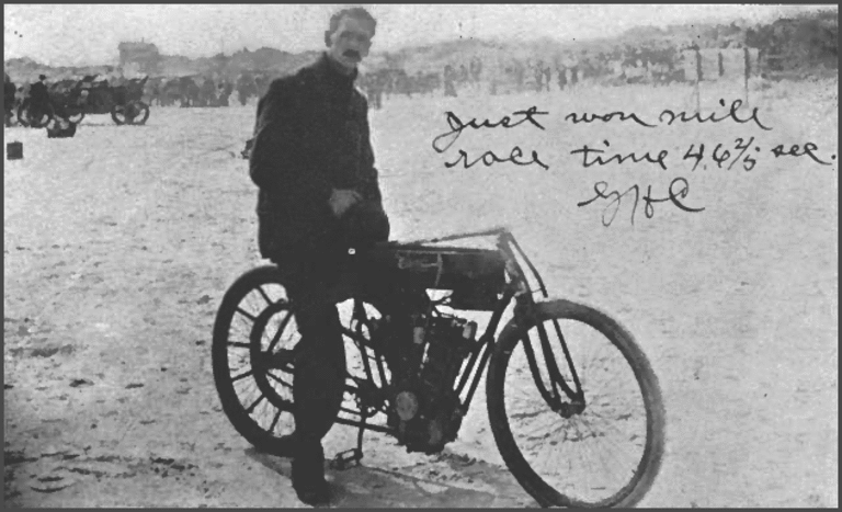 Postcard showing Glenn Curtiss astride his record setting 1907 twin cylinder motorcycle at Ormond, Florida.  Inscribed in Curtiss' handwriting, &quot;Just won mile race time 46 2/5 sec. GHC&quot;.