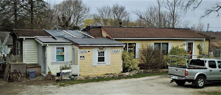 The house at 4561 Main Road in Tiverton, Rhode Island has signs on it which read "Tribal Office" and "Trading Post".  On the flag pole outside are flags reading "The Royal Council of Seven Royal House / Pokanoket Tribe / Pokanoket Nation" and
