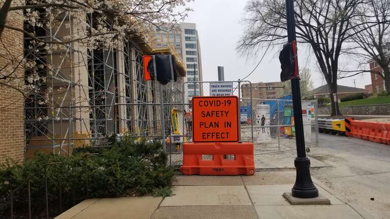 A sign on a construction site for COVID-19 in Downtown State College, Pennsylvania.