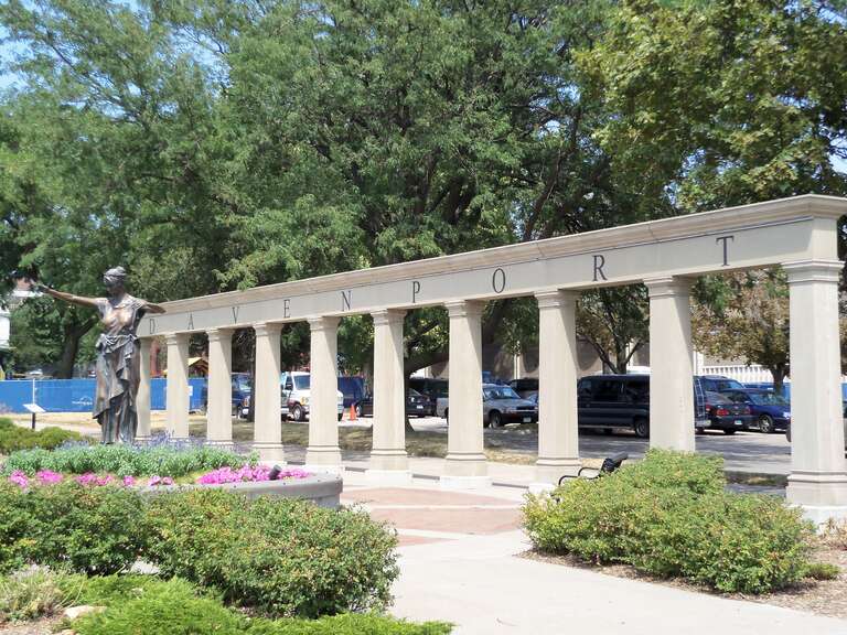A sign for Davenport, Iowa at the foot of the Centennial Bridge.  The statue is a replica of Lady of Germania.  It stood in Washington Square, which is located just behind the sign where the YMCA is now located.
