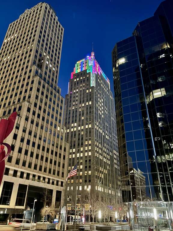First National Center in downtown Oklahoma City at night, with the upper setbacks of the building illuminated in multi-color lights.