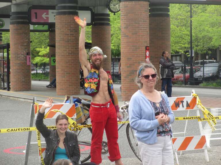 My friend Zach, in red pants, says hello. Passing out flyers for Bellingham's 2014 World Naked Bike Ride which is planned for Friday, June 6th. 4PM painting party at yard by HUB bicycle shop, ride through Downtown starts around 6 followed by a dance.