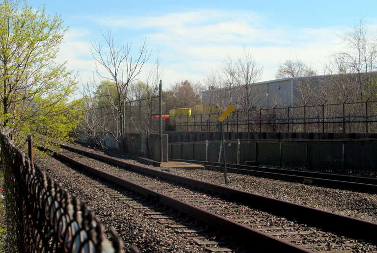 The north end of the tunnel that carries the Orange Line and Haverhill Line under the Medford Branch, seen in April 2017. The track at left, formerly used to access the Medford Branch, was disused at the time; it was repaired around 2019 for use as a