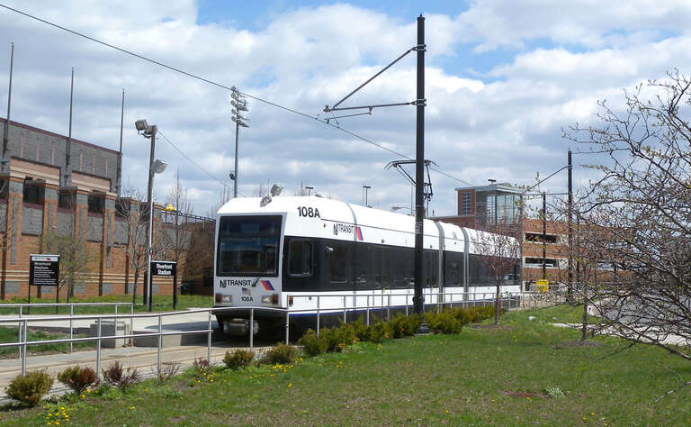 Looking east as trolley arrives at en:Riverfront Stadium (NLR station) on a sunny midday.