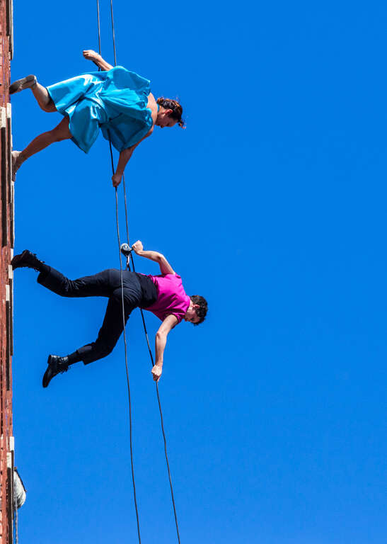 The dance troop, Bandaloop, perforned a 'vertical dance' on the face of one of the walls of the Westin Harborview Hotel in Portland, Maine with two short performances at mid-day.  Lots of harsh light.  
A pioneer in vertical dance performance,