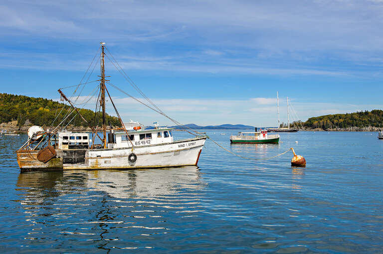 500px provided description: The Wind Spirit lobster boat in the ocean near Bar Harbor as seen from the tour boat from Bar Harbor Whale Watch Lighthouse Tour in October. [#sky ,#landscape ,#october ,#sea ,#water ,#reflection ,#travel ,#island ,#blue