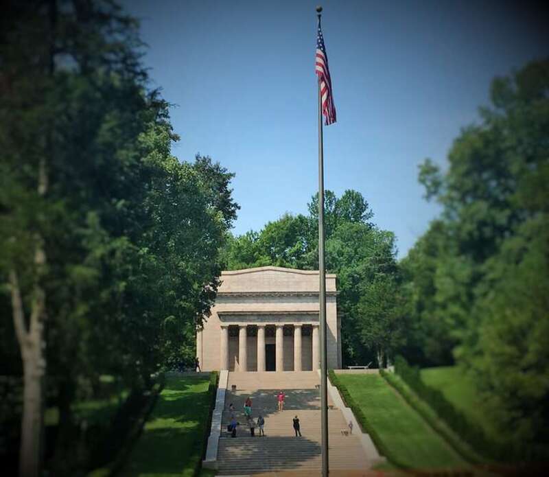 Photo of the Monument Building protecting the model of the Log Cabin home that Abraham Lincoln was born in.
