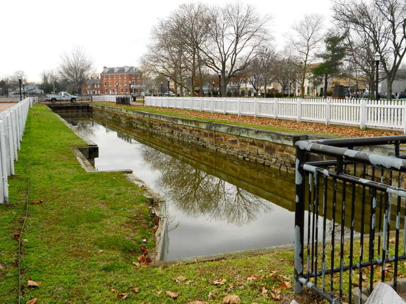 Eastern lock of the Chesapeake and Delaware Canal (now out of use).  The Van Amringe house in the background. Listed as the Eastern Lock of the Chesapeake and Delaware Canal on the NRHP since April 21, 1975, in Battery Park, Delaware City, Delaware.