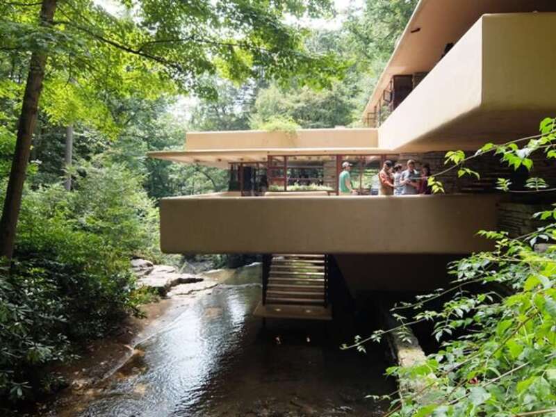 A photograph of the Frank Lloyd Wright designed house Falling Water from the side showing the river flowing beneath.