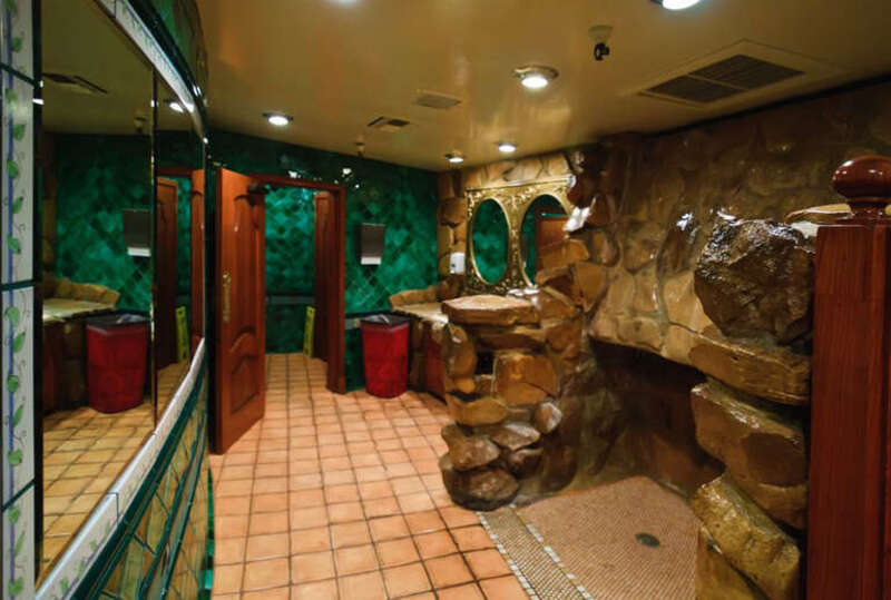 Men's restroom at Madonna Inn.  On the right is a large urinal which flushes via a waterfall from the rocks above.