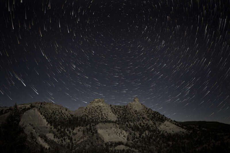 500px provided description: Star trails over Chimney Rock National Monument. [#mountains ,#stars ,#colorado ,#astrophotography ,#star trails ,#night sky ,#rock formation ,#chimney rock ,#pagosa springs ,#comet trails]