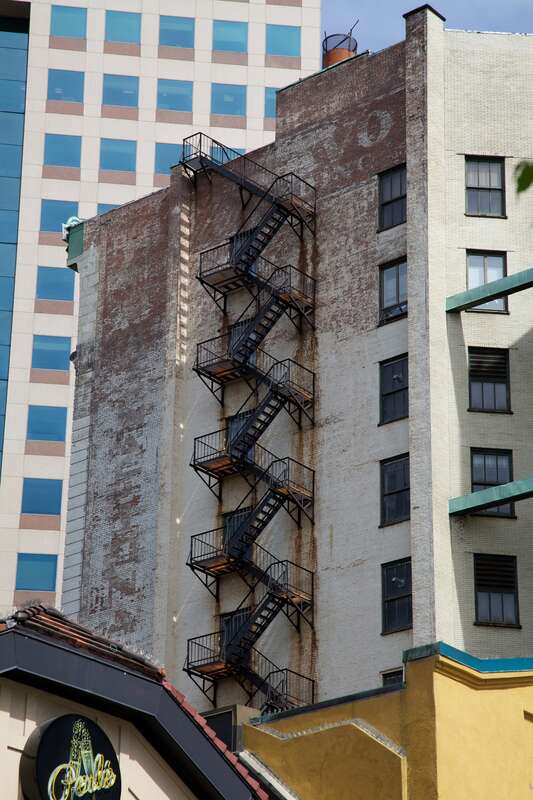 Fire escape?

There seems to be more iron in the rust trails dripping down the building than on the steel.