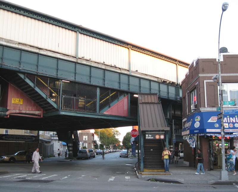 Looking southeast along 85th Street at en:18th Avenue (BMT West End Line) station near dusk of a sunny day.