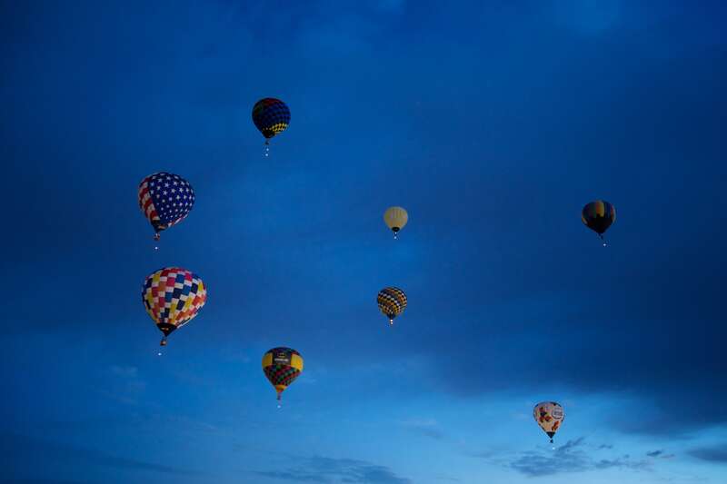 Dawn Patrol is a small group of balloons that go up before the rest to check conditions. They light up before dawn for a 5:45am departure. The light below each balloon is for night flying. Albuquerque International Balloon Fiesta, 2012. Over 750