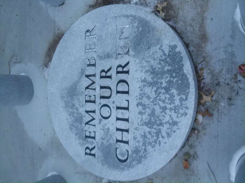 The center stone of the Clyde Children's Memorial, built in 2017, with some snow on it. It says &quot;REMEMBER OUR CHILDREN&quot;. Connected to the Clyde cancer cluster.