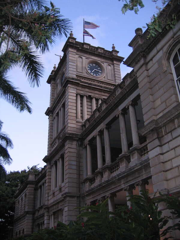 Picture of the Aliʻiōlani Hale clock tower looking upwards from the side.
