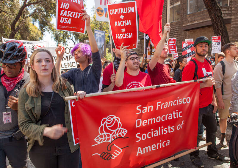 Protesters hold a banner for the San Francisco Democratic Socialists of America at a Patriot Prayer counter-protest in San Francisco.