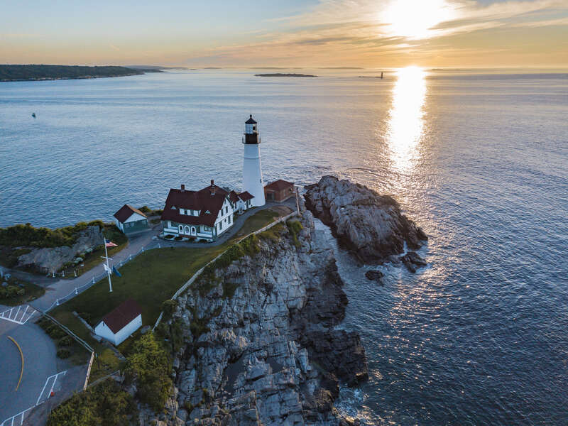 This photo was taken with a drone of the Portland Head Light at sunrise.