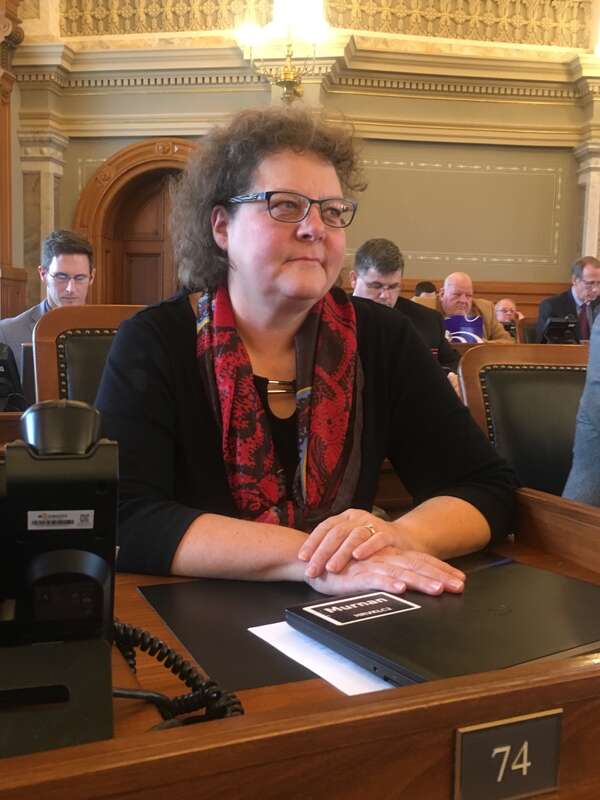 Kansas State Representative Monica Murnan at her desk on the floor of the Kansas House of Representatives